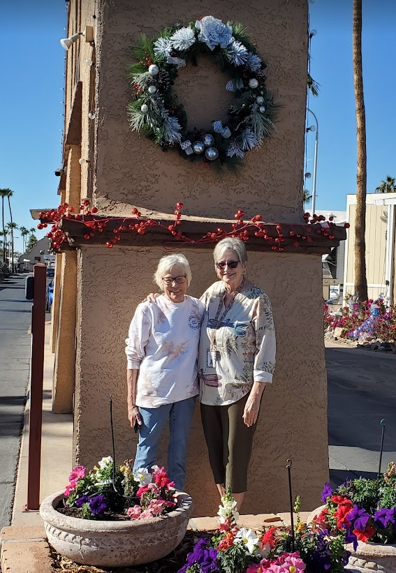 Residents posing under Christmas wreath on gate